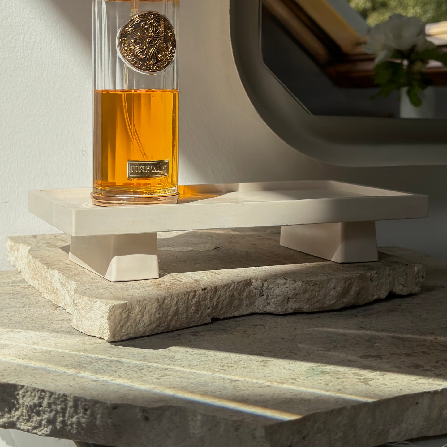 Malmo Home Poise Rectangle plinth styled with a perfume bottle on a stone surface in natural light