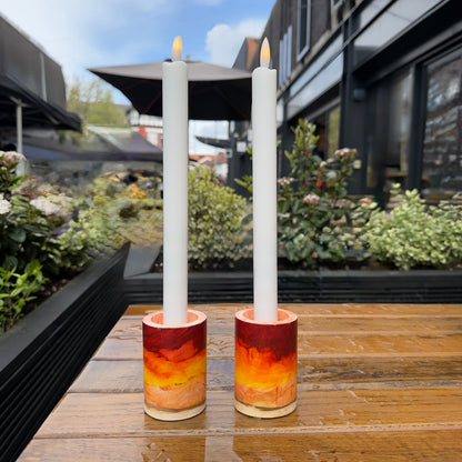 Set of two handmade candlestick holders in warm sun tone with flame-free, battery-operated candles for safe table lighting