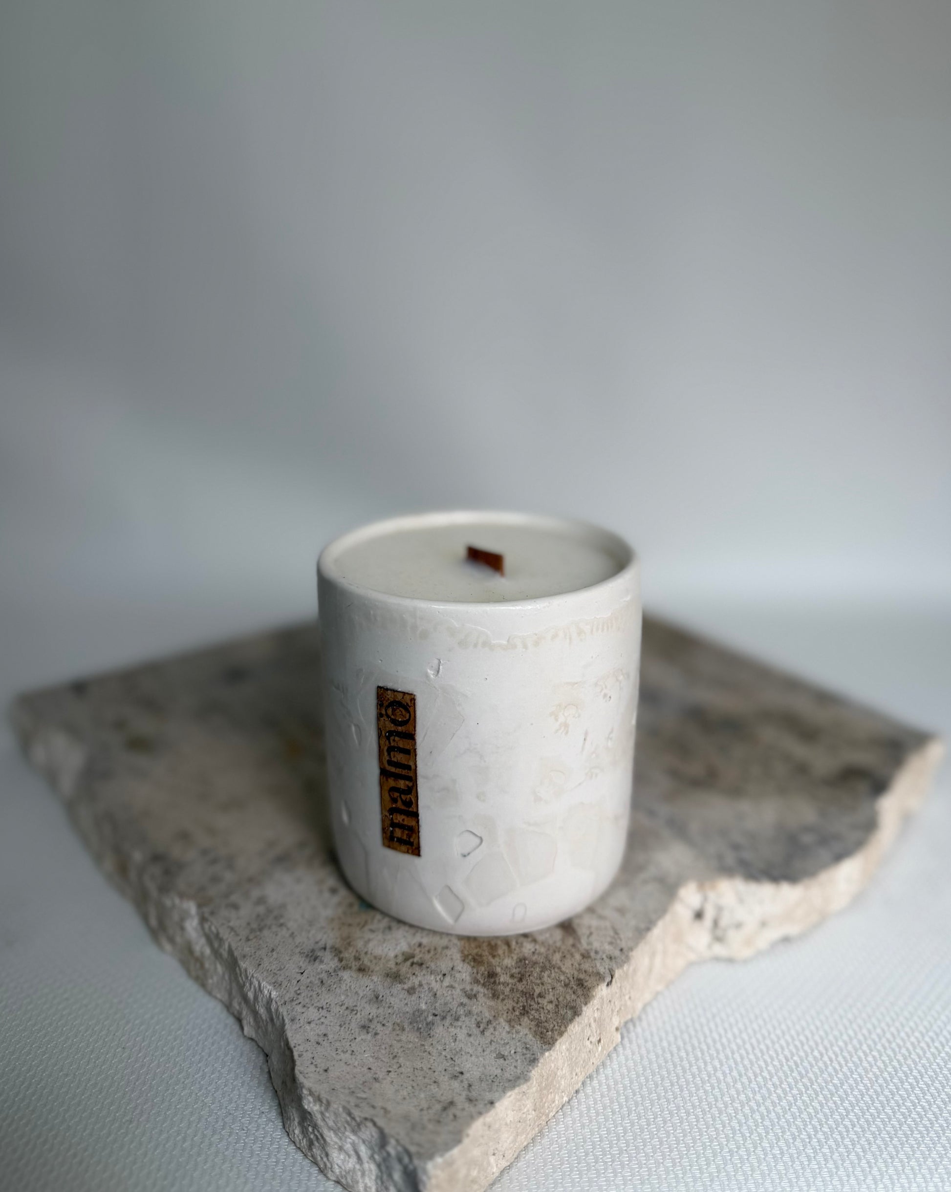 Malmo Home Natural candle pot, unglazed stone-effect ceramic, front view on linen surface
