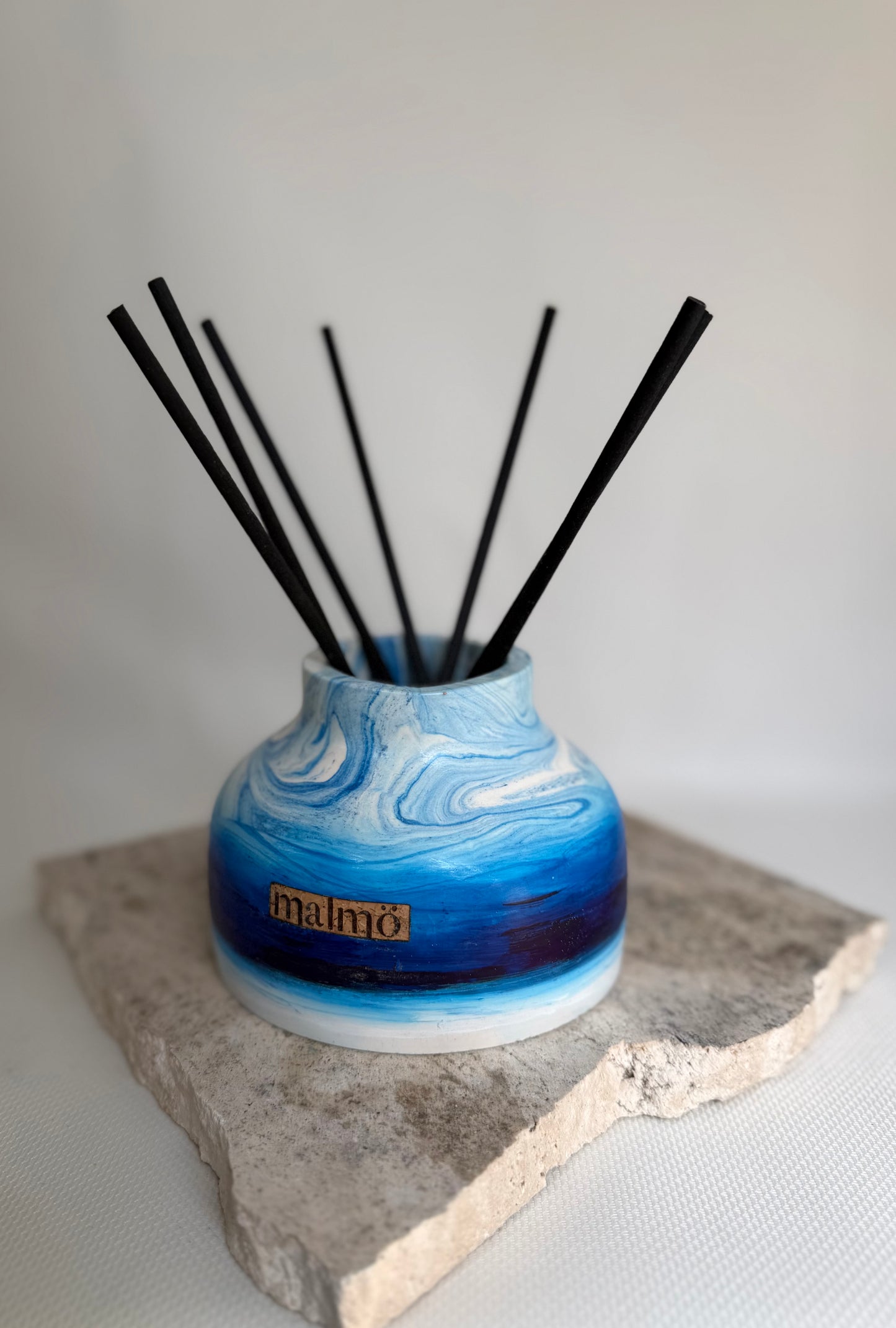 Malmo Home Sky Drom reed diffuser, pale blue stone-effect ceramic vessel with rattan reeds, front view
