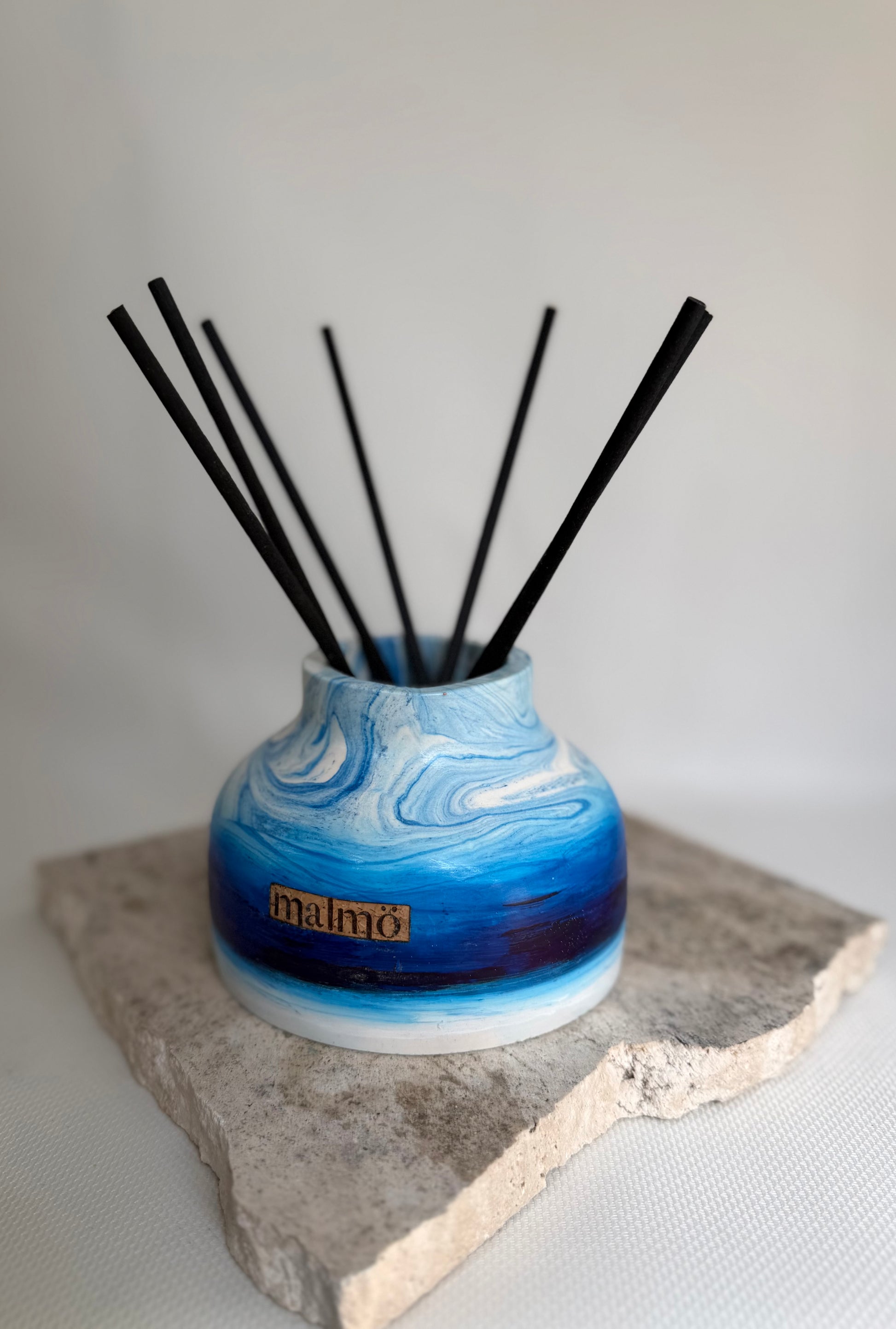 Malmo Home Sky Drom reed diffuser, pale blue stone-effect ceramic vessel with rattan reeds, front view
